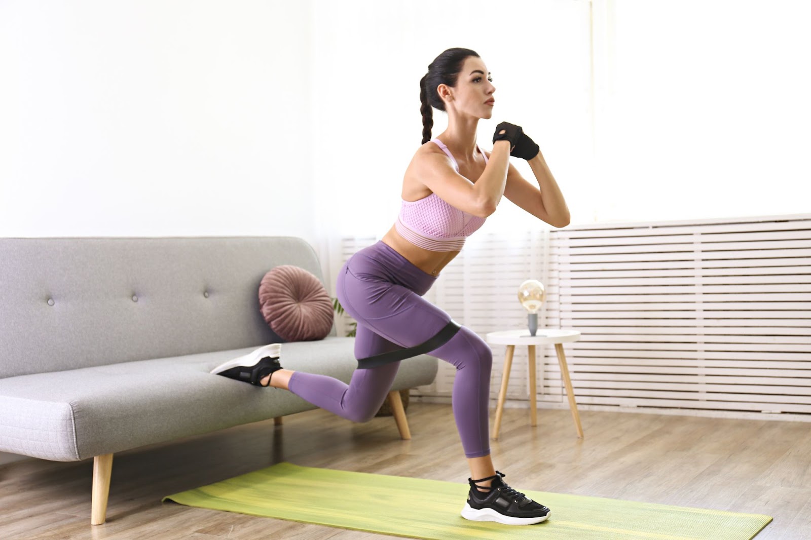 Fit woman in purple exercise clothing performing Bulgarian Split Squat.