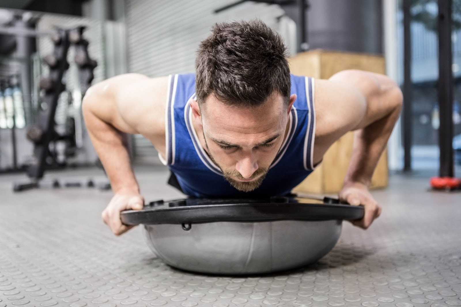 Man performing a push up on a BOSU ball.