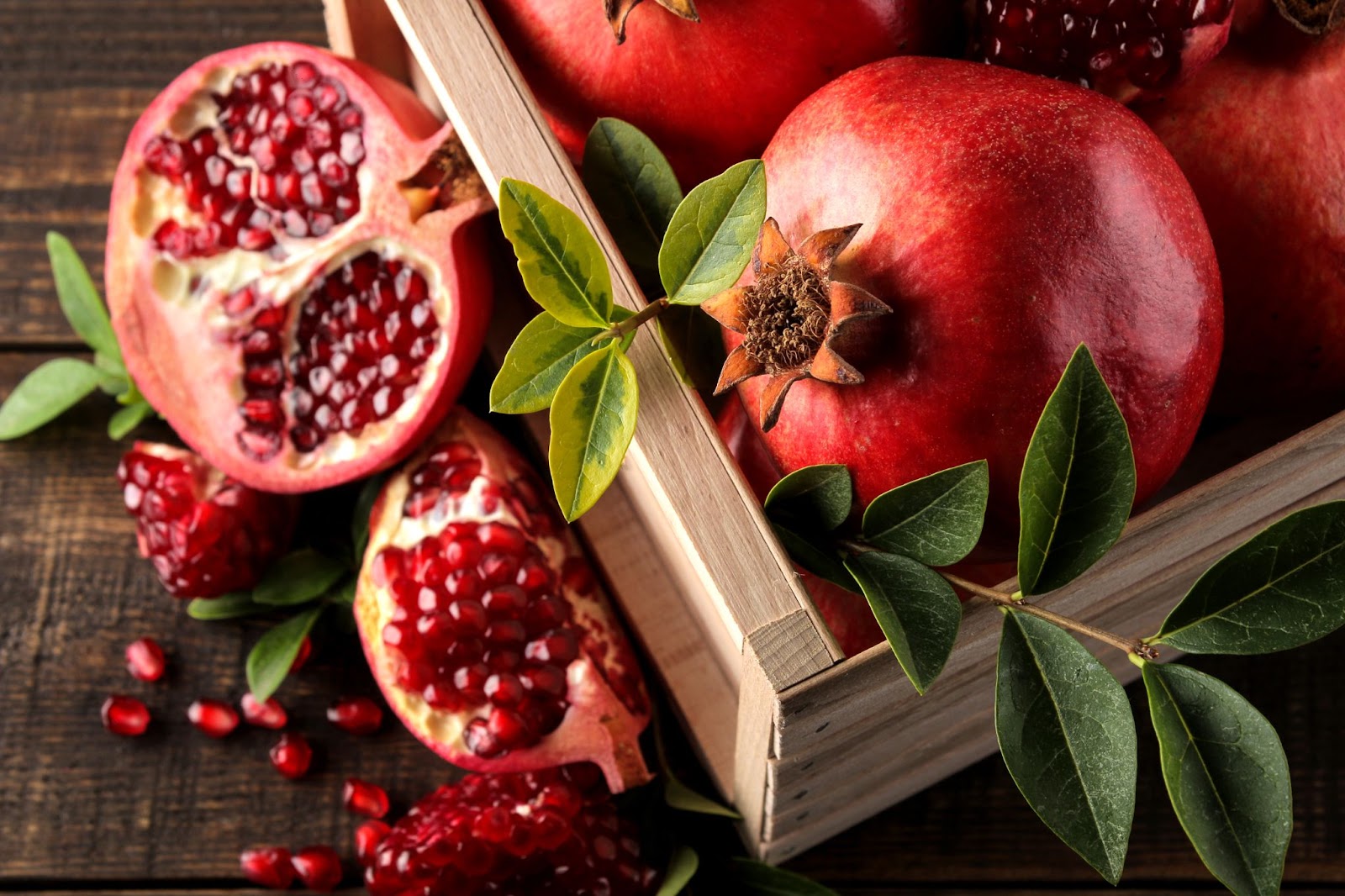 Pomegranate fruit in a wooden box.