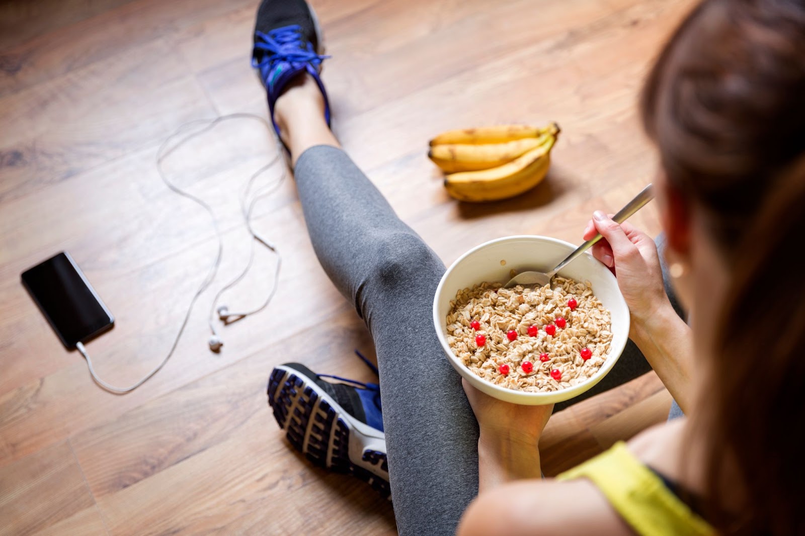 Woman eating oatmeal with cranberries after a workout