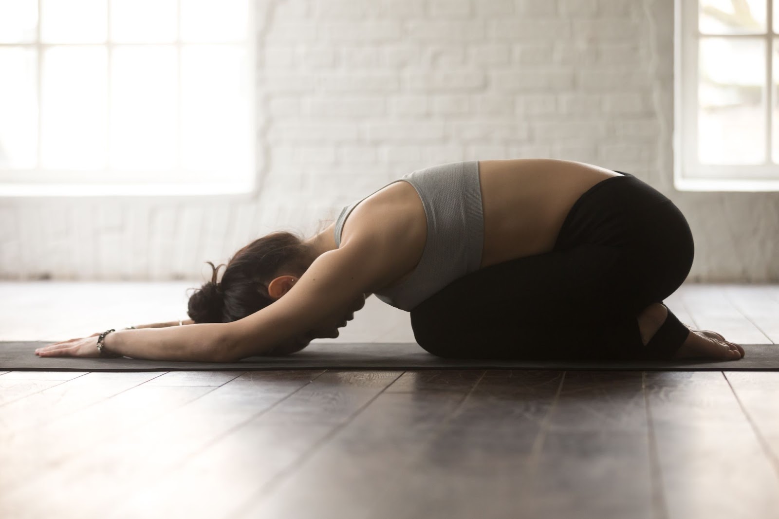 Fit woman performing a child’s pose exercise