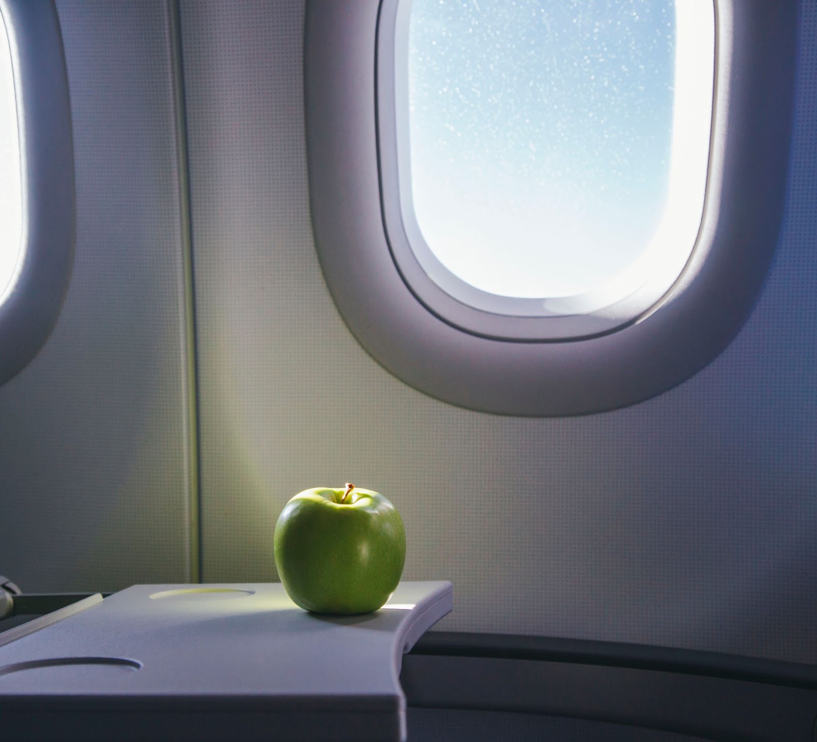 Green apple being eaten on an airplane
