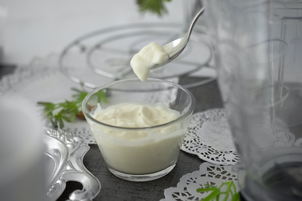 Spoon going into a glass bowl of yogurt