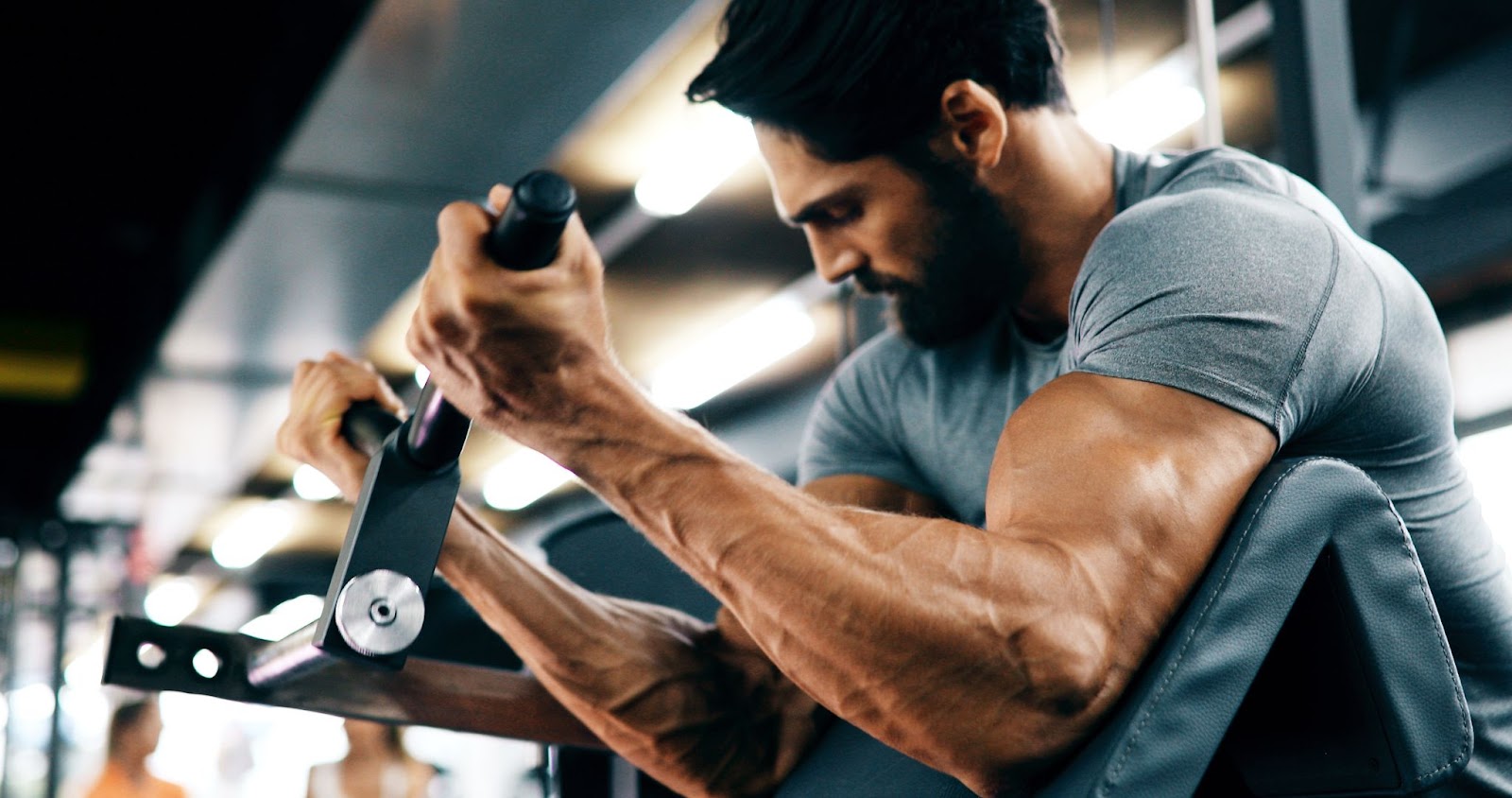 Young, fit man doing a bicep curl on a machine