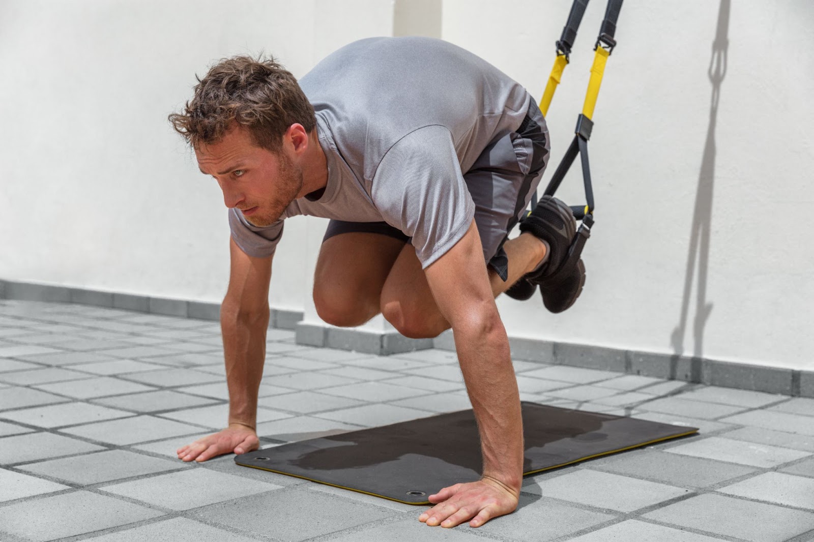 Man doing TRX exercises at a gym