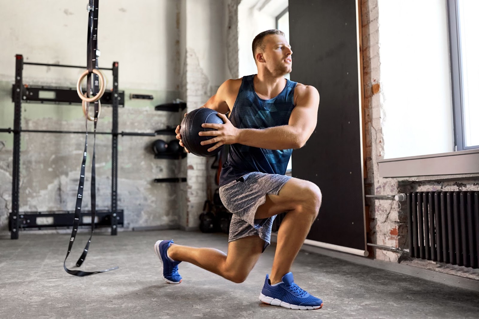 Man performing a lunge twist in a crossfit-style gym