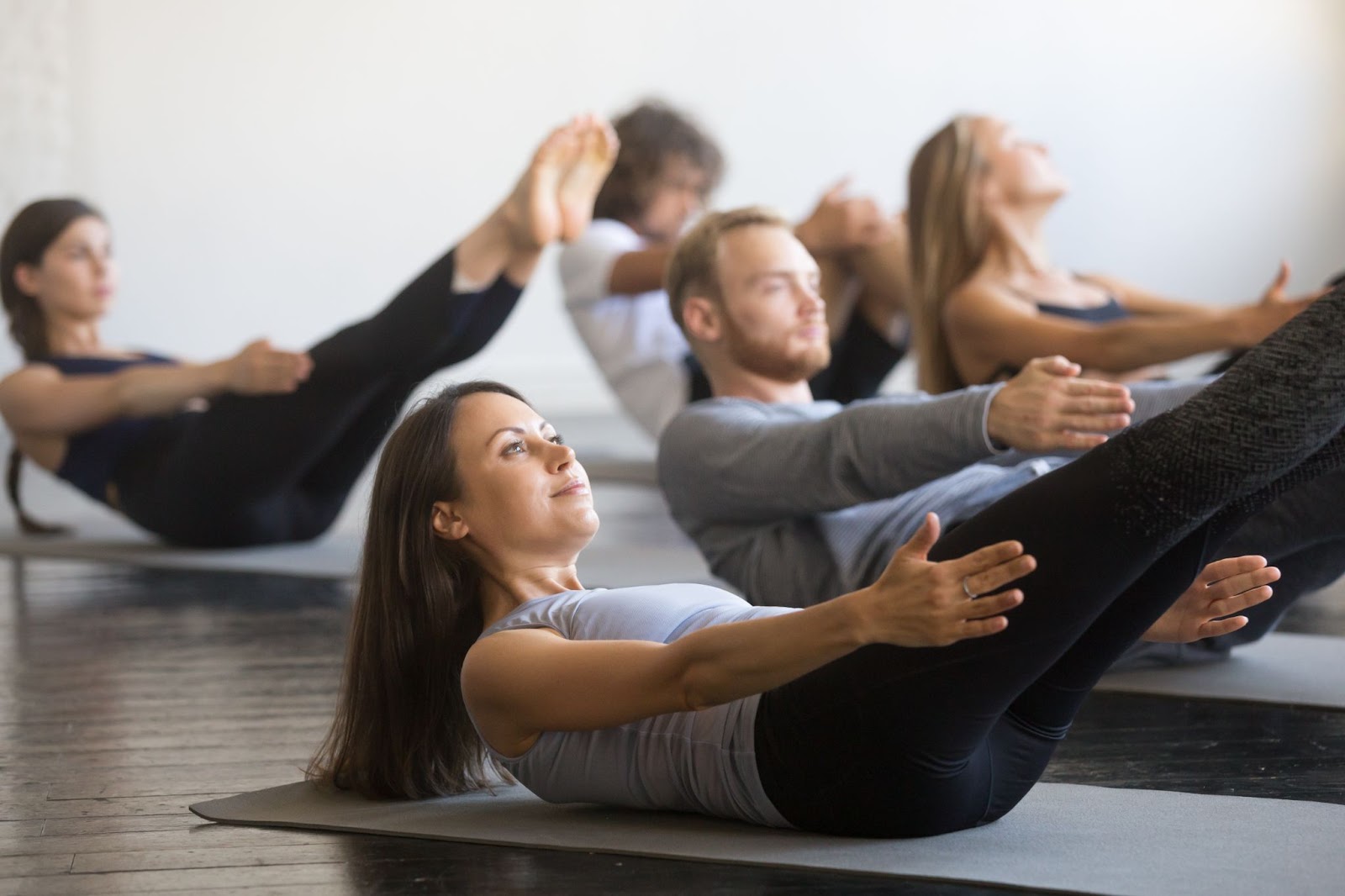 A Pilates class performing a Pilates one hundred exercise