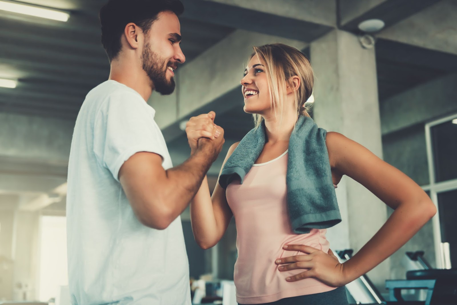 Happy couple smiling next to each other at the gym