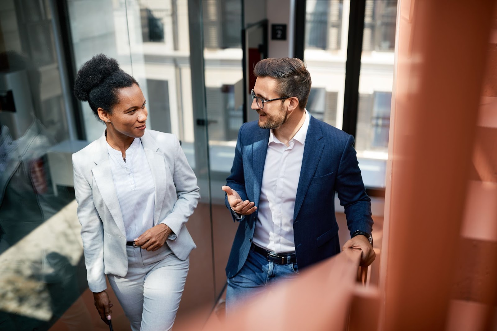 Man and woman walking up stairs at their office