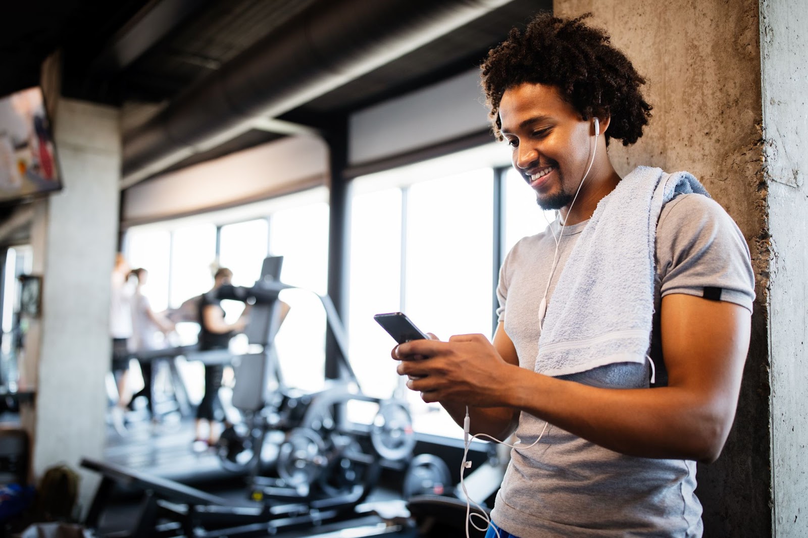 Man in a gym reading phone reminders