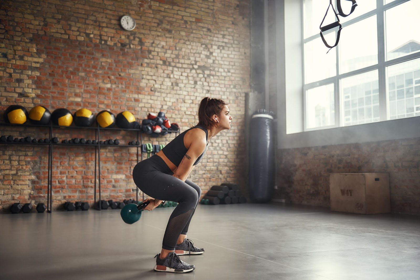 Woman in a gym performing a kettlebell swing