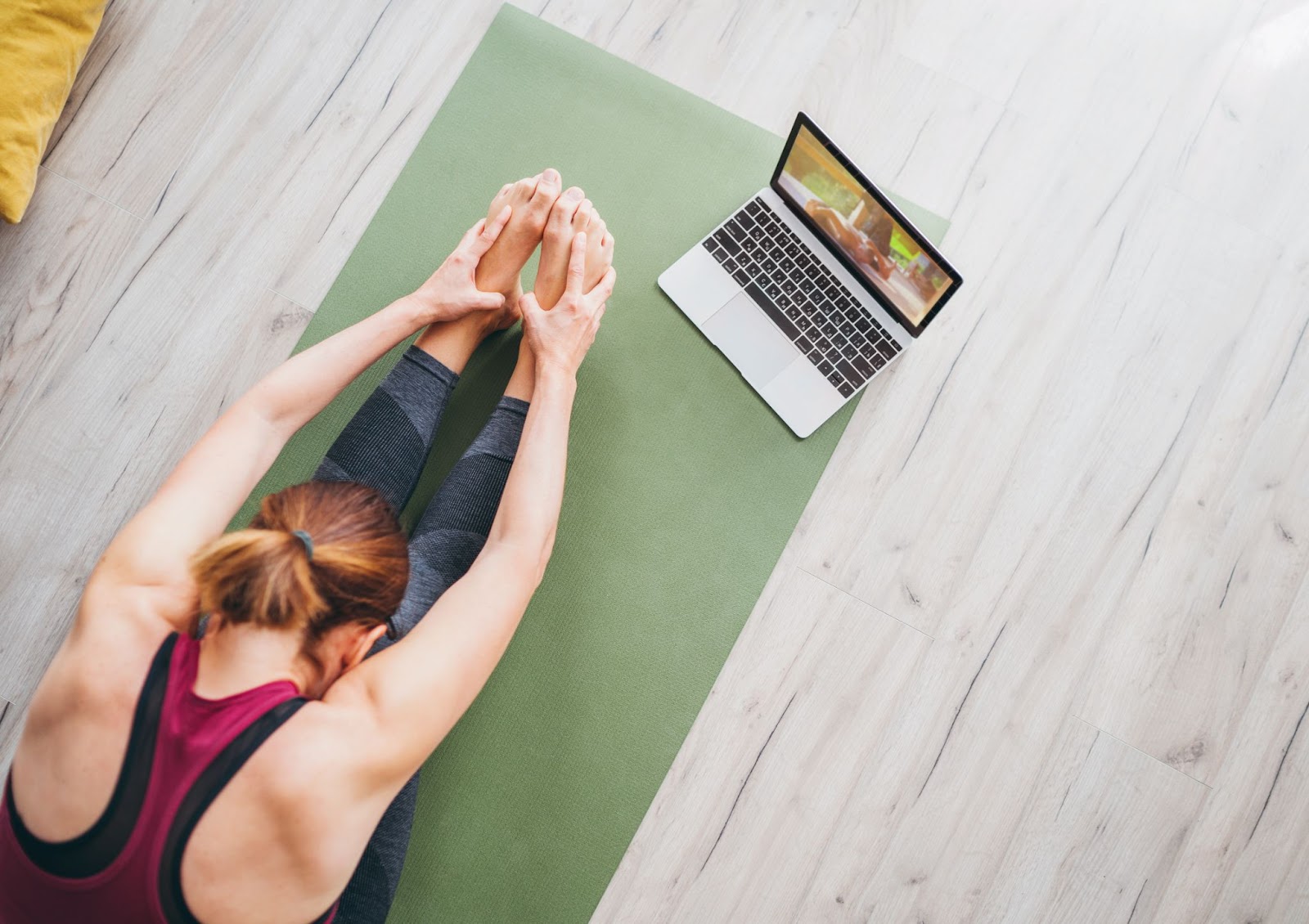 Young fit woman taking an online Pilates class at home