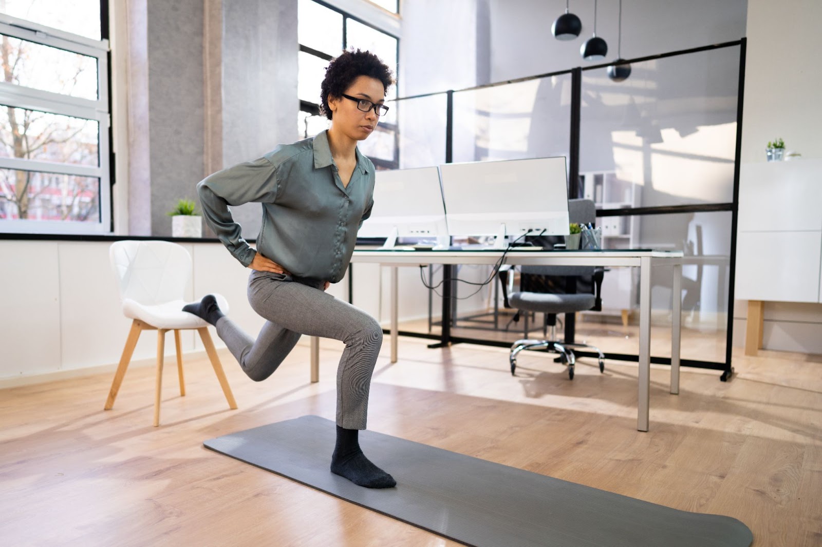 Woman in an office setting performing a single-leg split squat