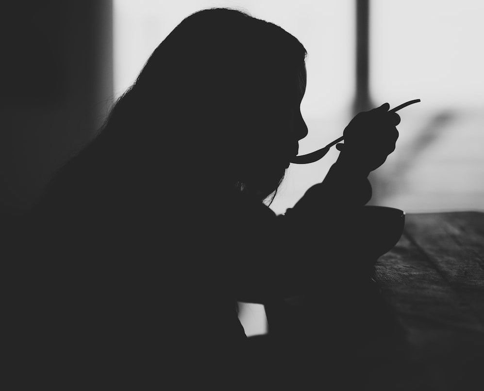 Black and white profile image of a woman eating
