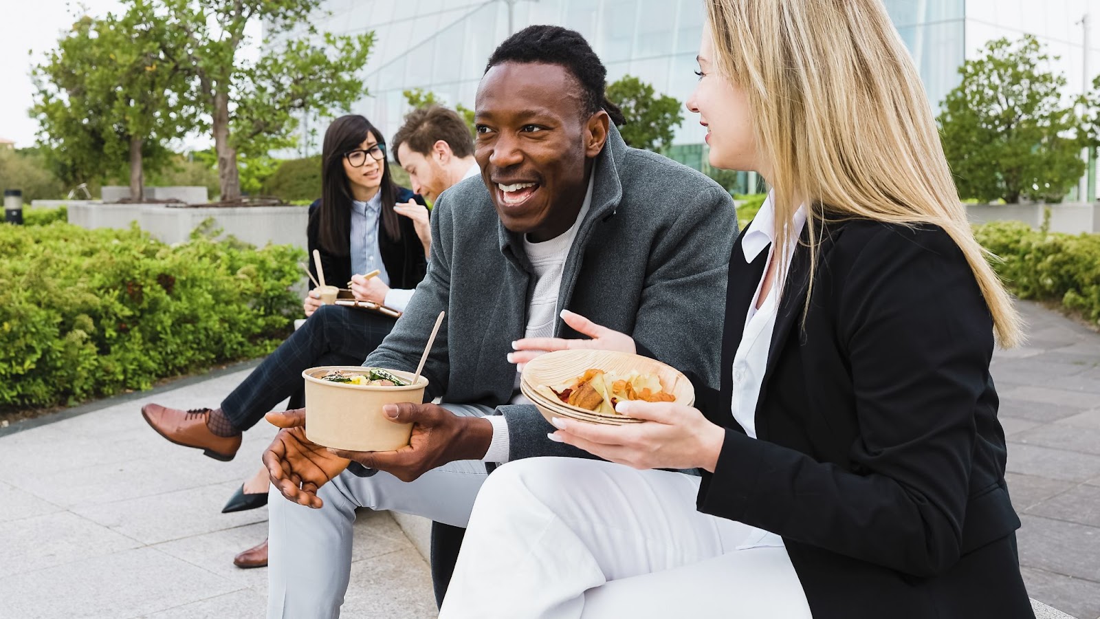 Business employees eating healthy lunch together on bench