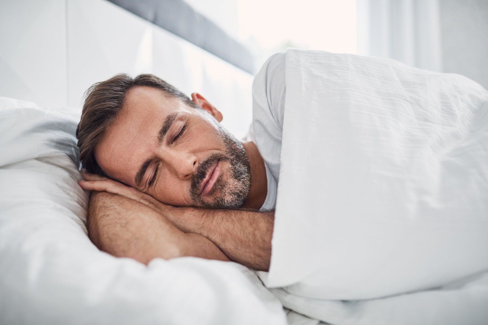 Fit man sleeping in his bed