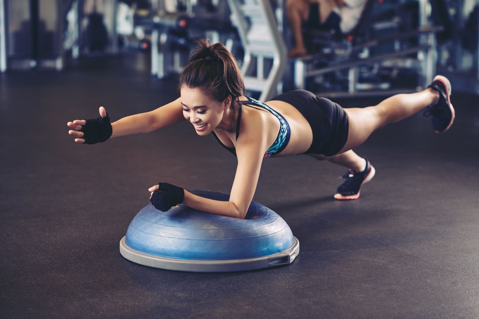Fit woman working out on a BOSU ball at a gym