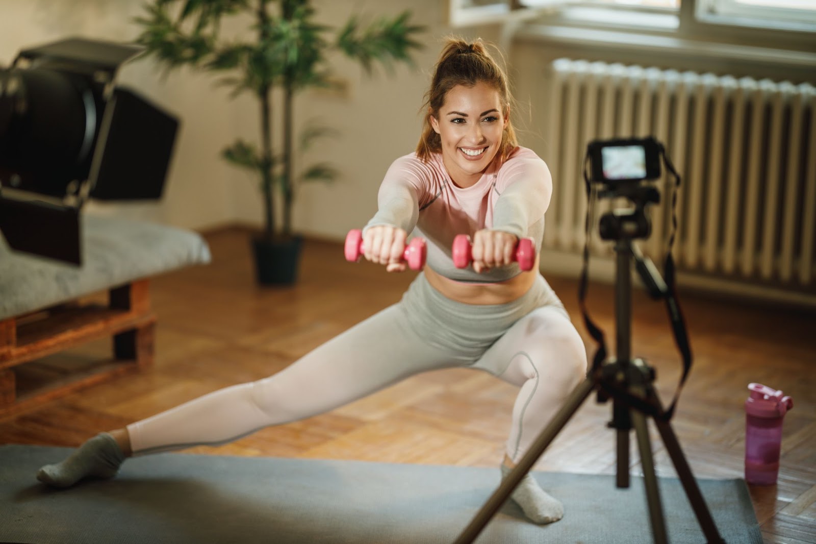 Fitness model recording a class from her living room