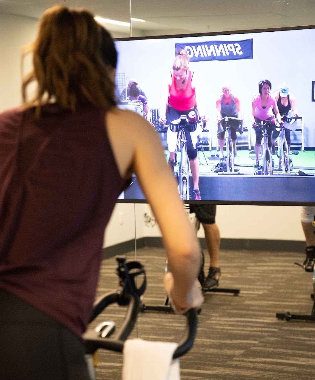 Image of person taking a SWEAT Pro cycling class from a commercial space