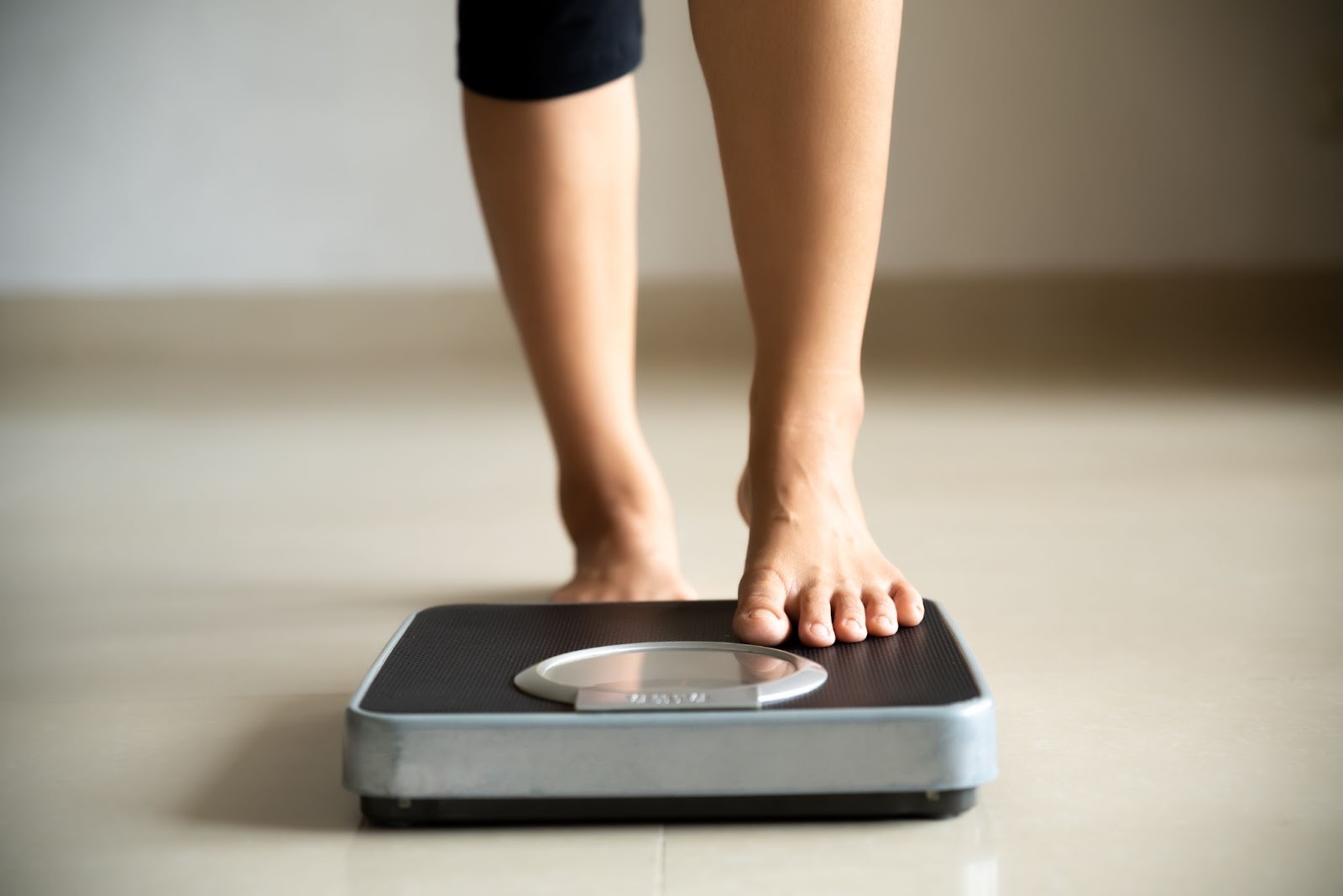 Woman nervously stepping on a scale to check her weight