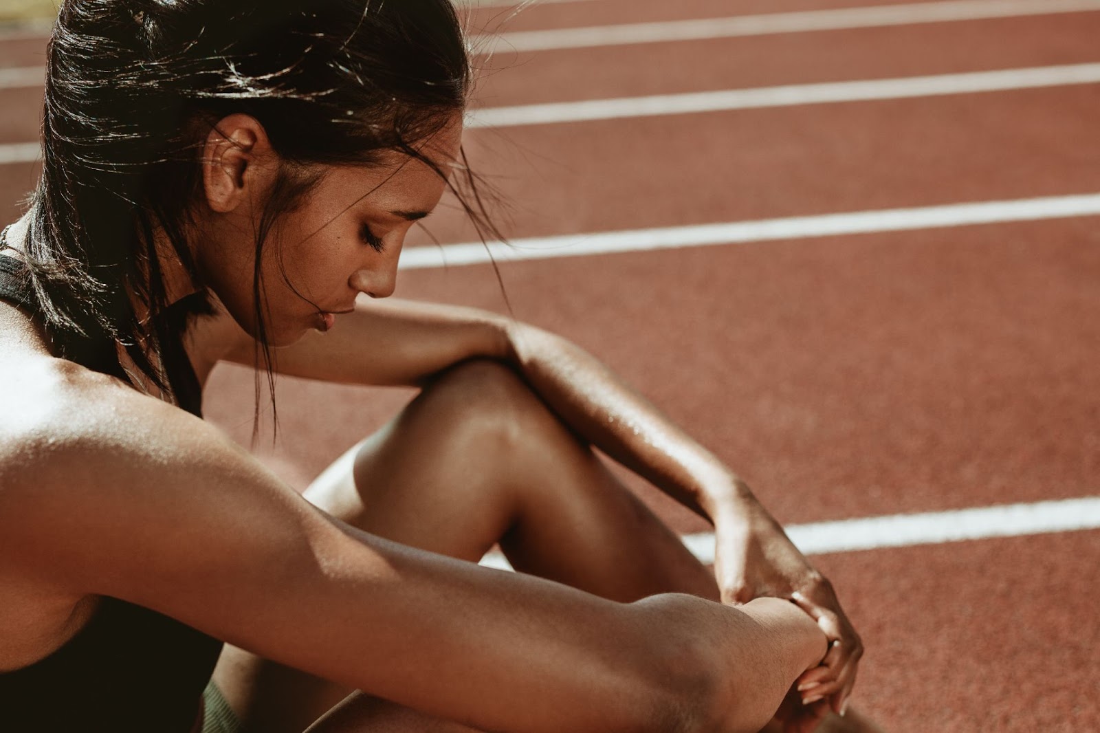 Fit woman sitting down on the running track