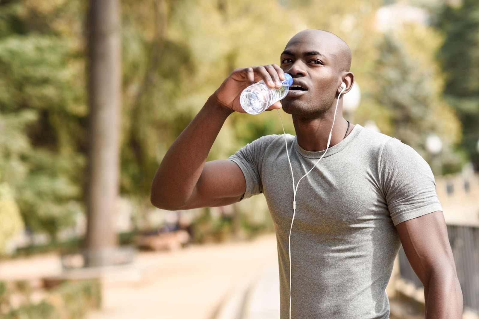 Fit young man drinking water before going for a run