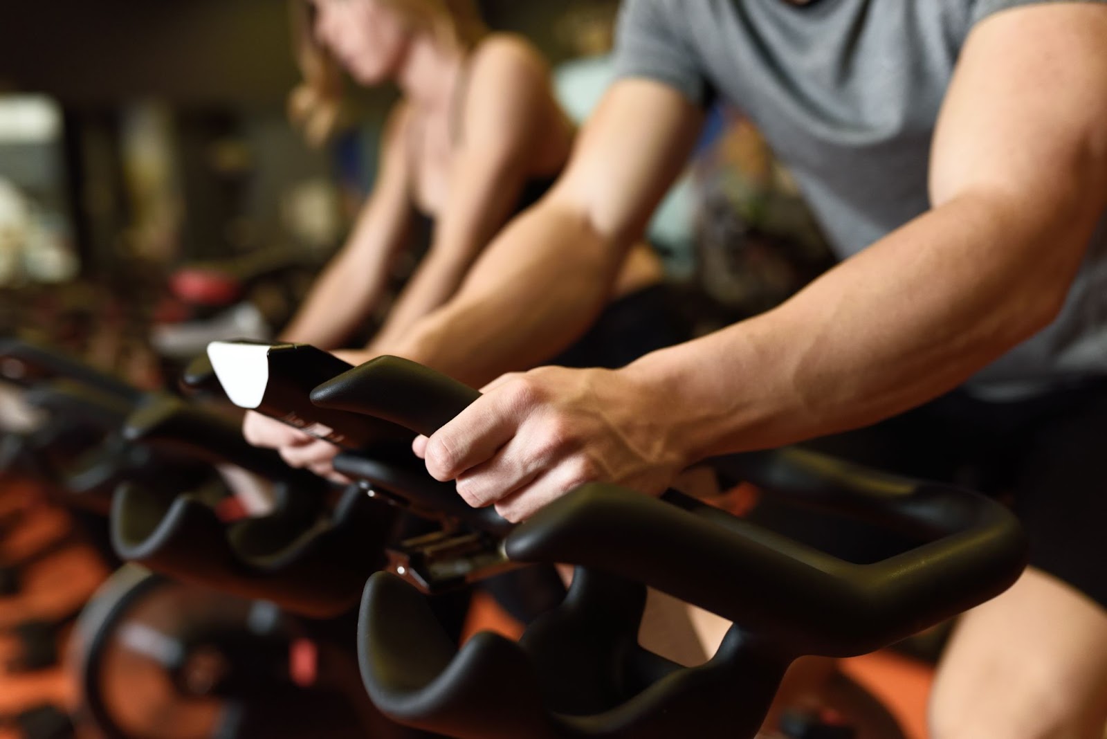 Man adjusting the music on his smartphone in a Spin class