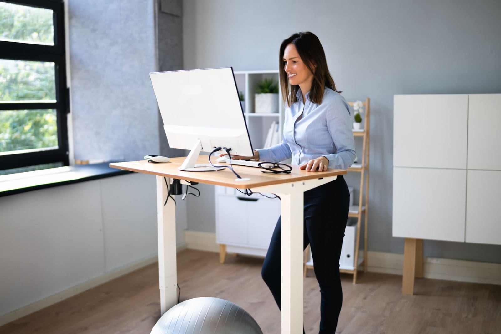 Smiling woman using a standing desk
