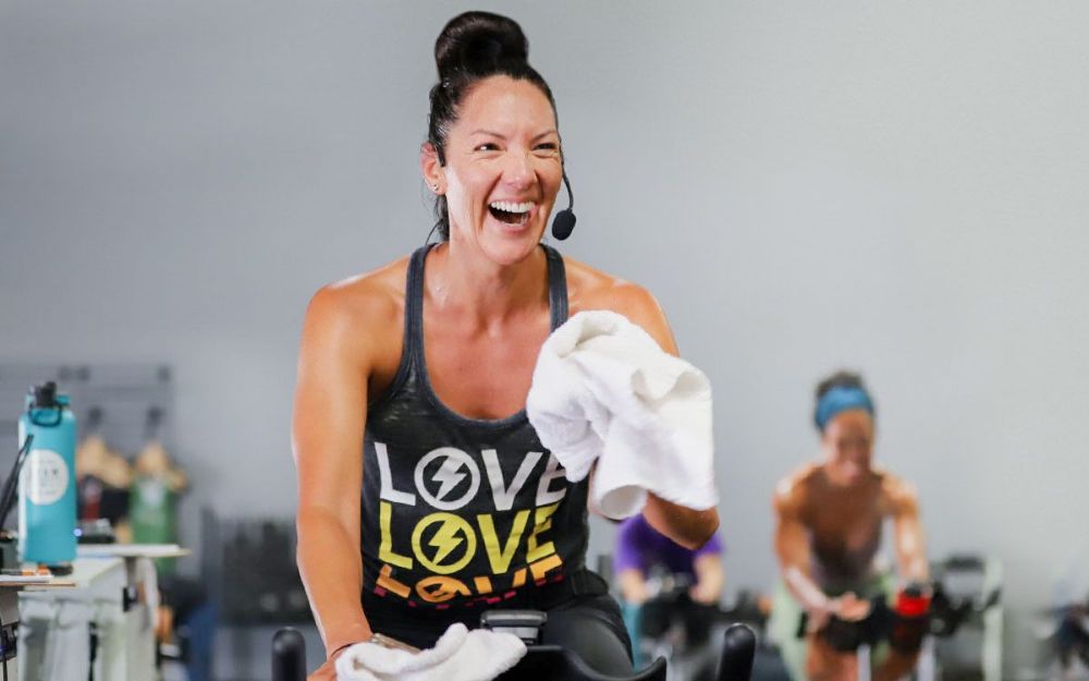 Studio SWEAT onDemand trainer laughing while teaching a class