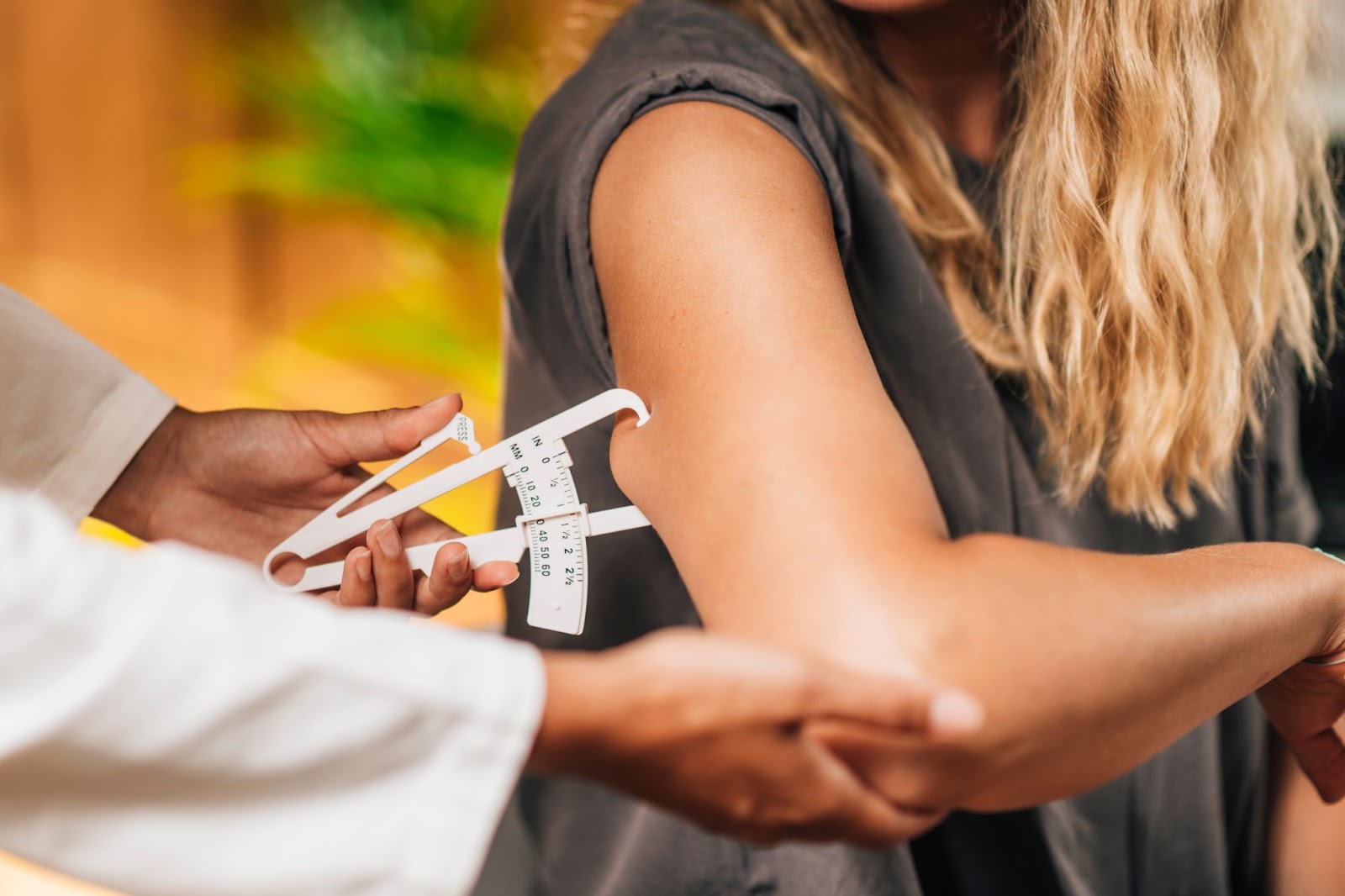 Doctor using a skinfold caliper on a woman