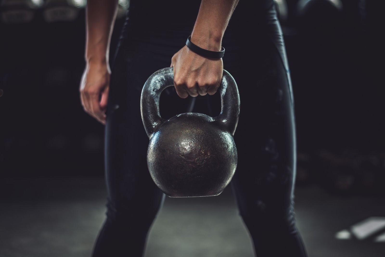 Closeup of a fit person holding a kettlebell in front of them