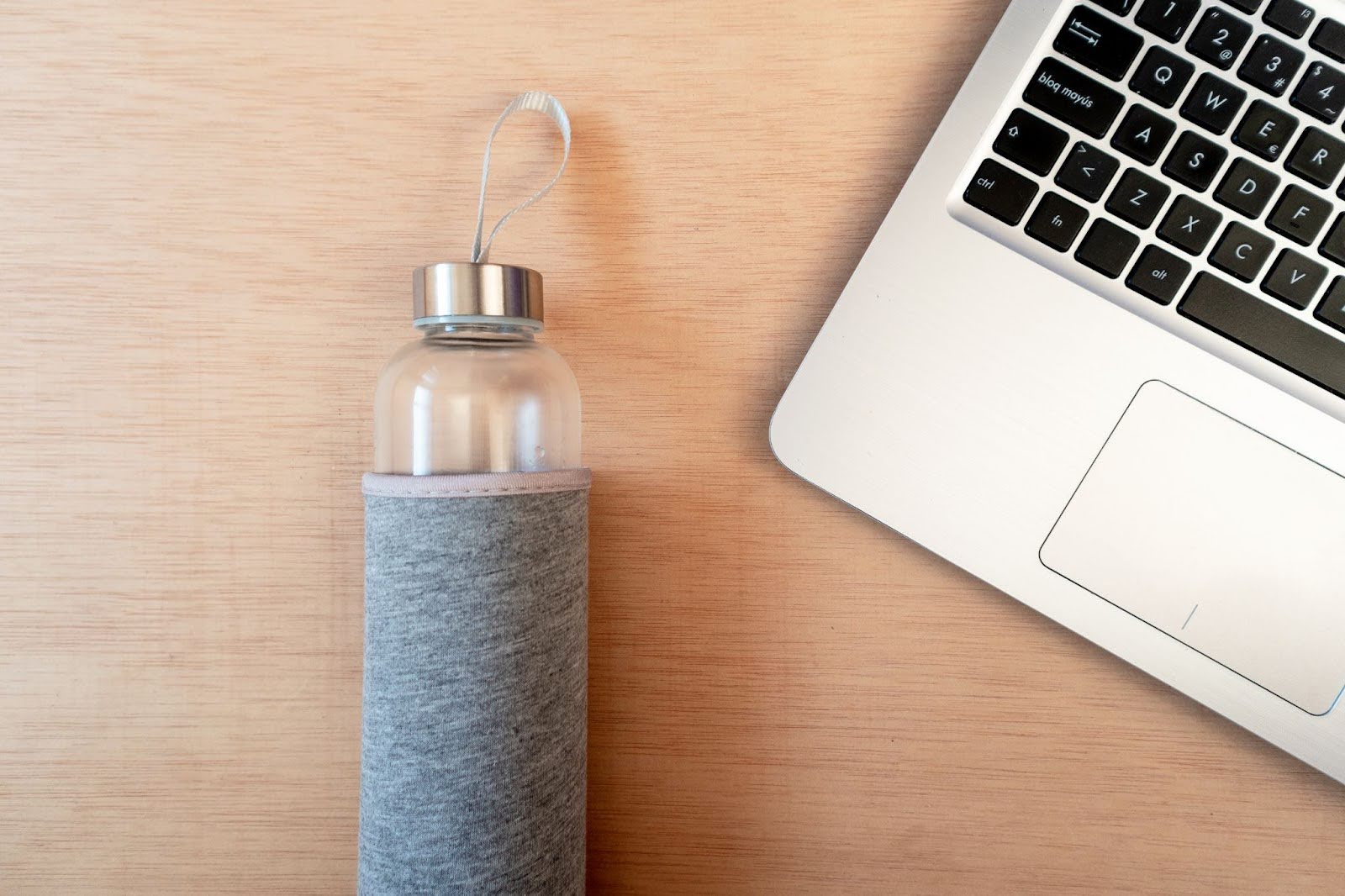 Close up of water bottle next to a laptop