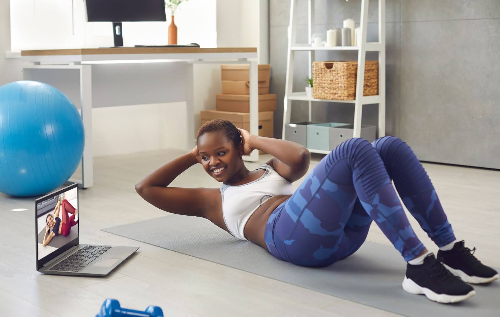 Fit woman taking a virtual fitness class at home