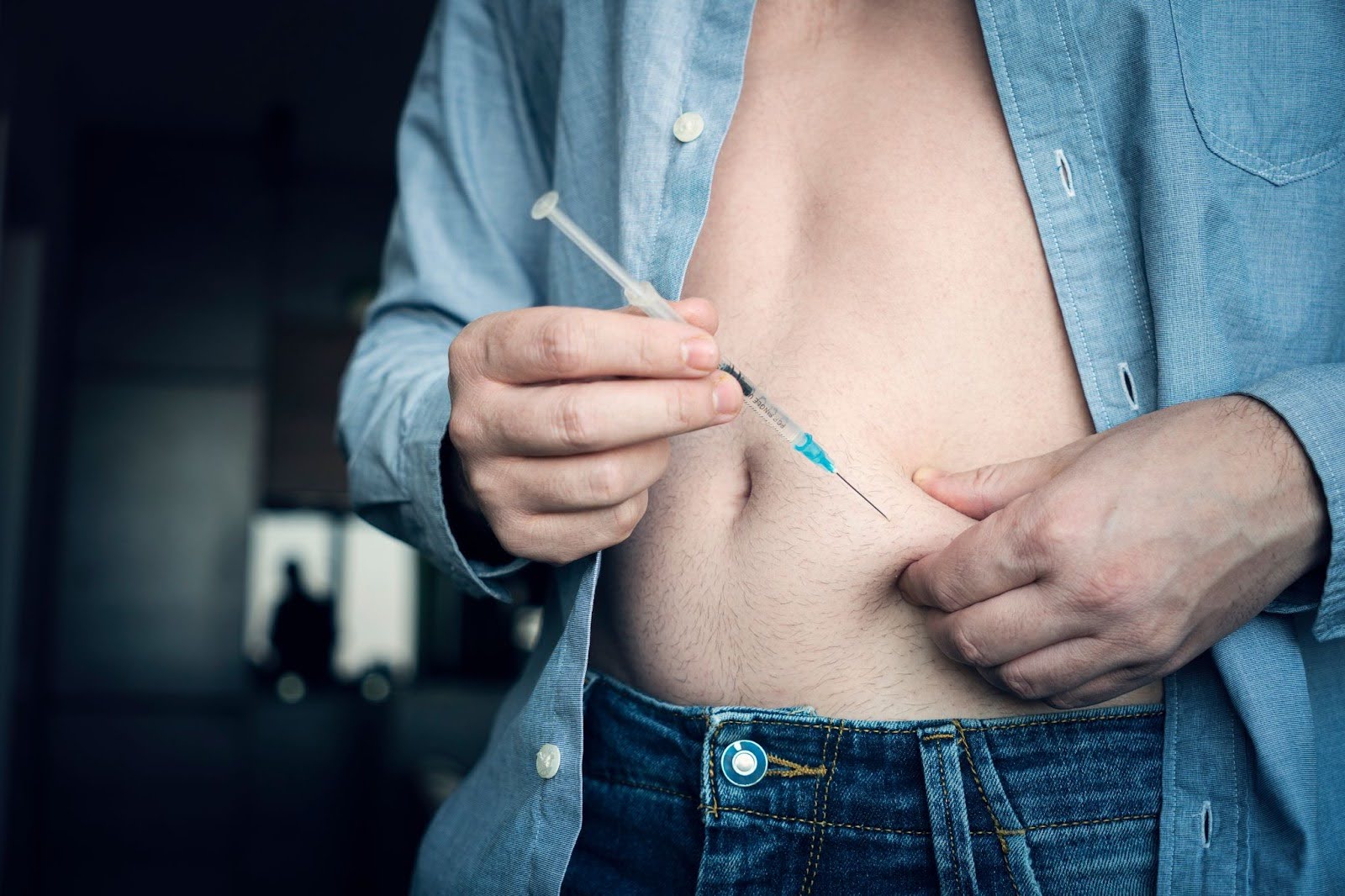 Image of man putting an Ozempic injection in his belly