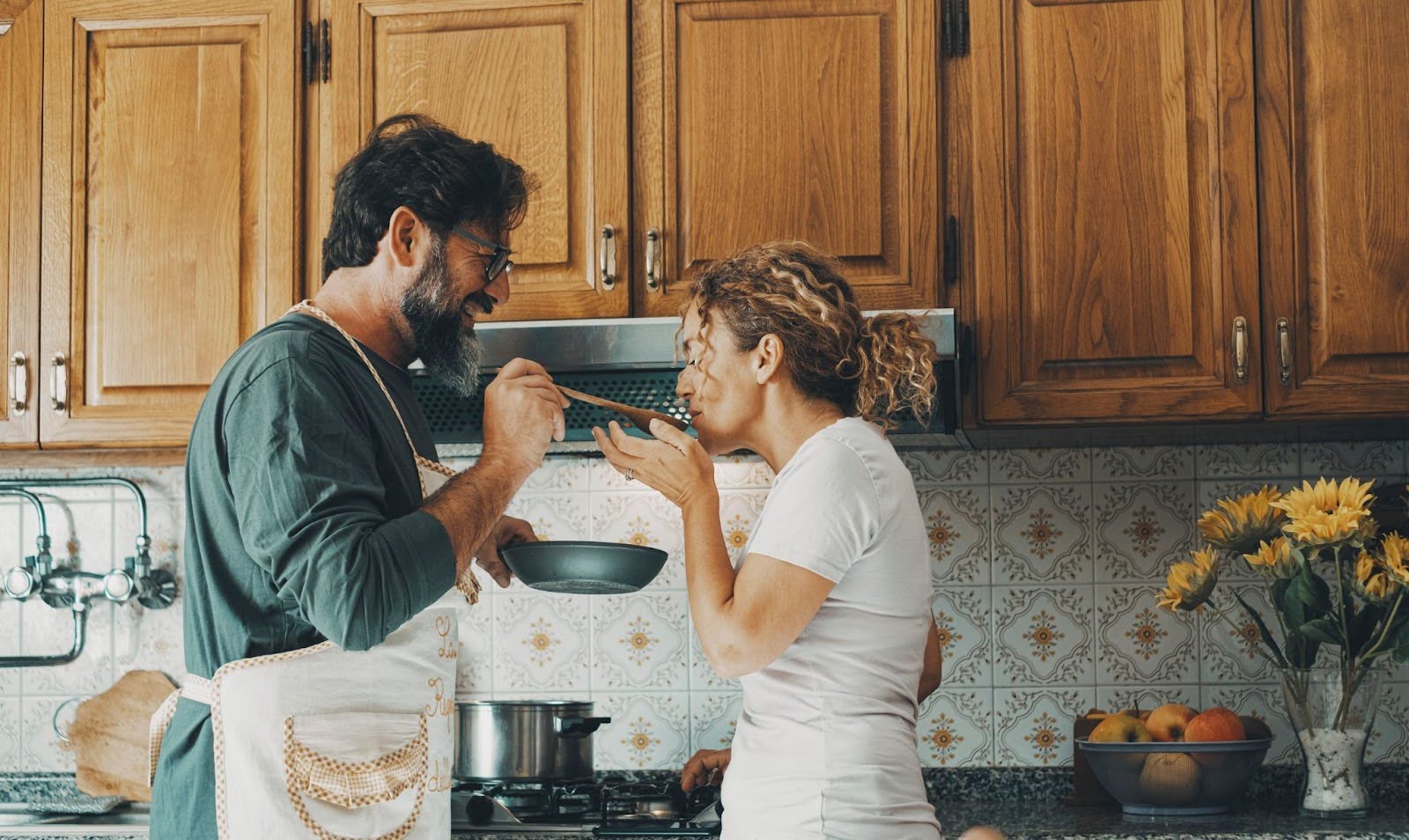Couple laughing and cooking together in a kitchen