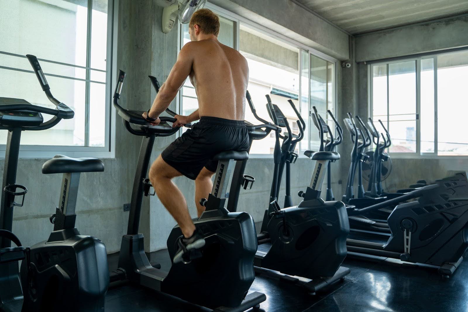 Fit man working out on an upright fitness exercise bike