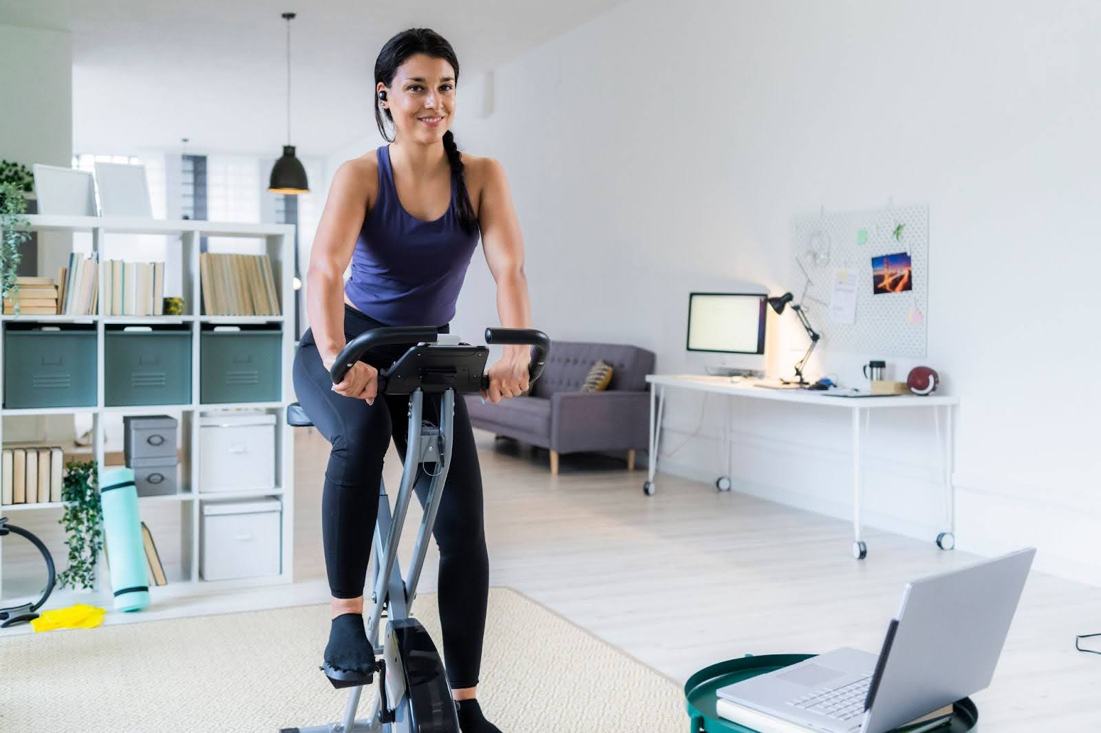 Happy woman on a folding exercise bike