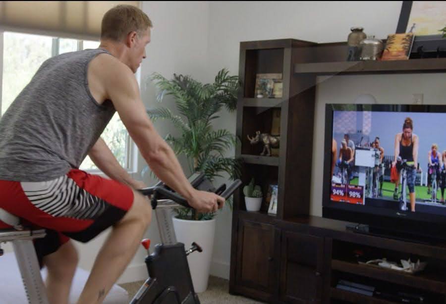 Studio SWEAT onDemand member taking a virtual cycling class