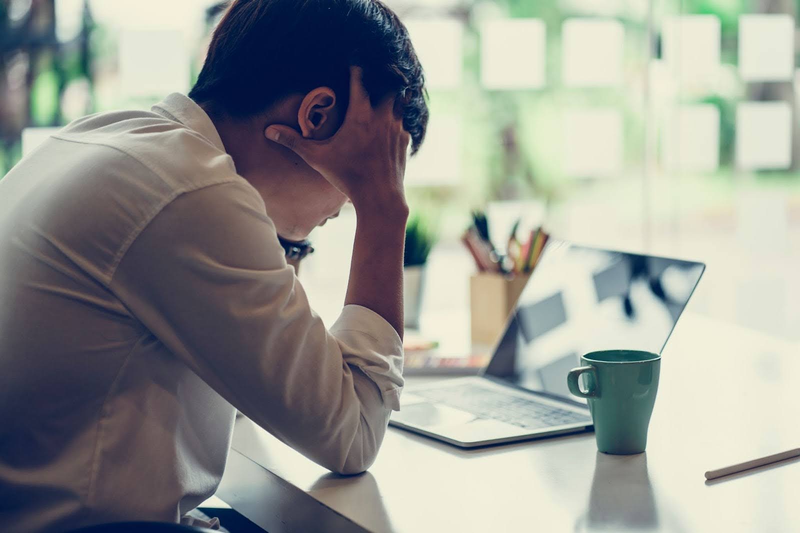 Stressed out man with his hands on his head, at his office