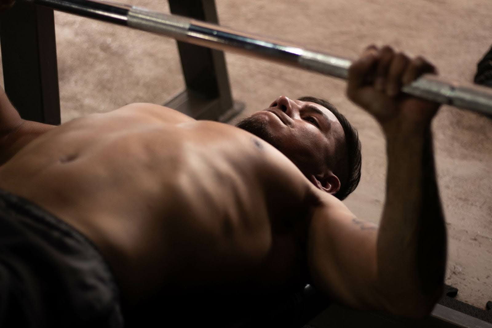 Fit man doing a barbell bench press